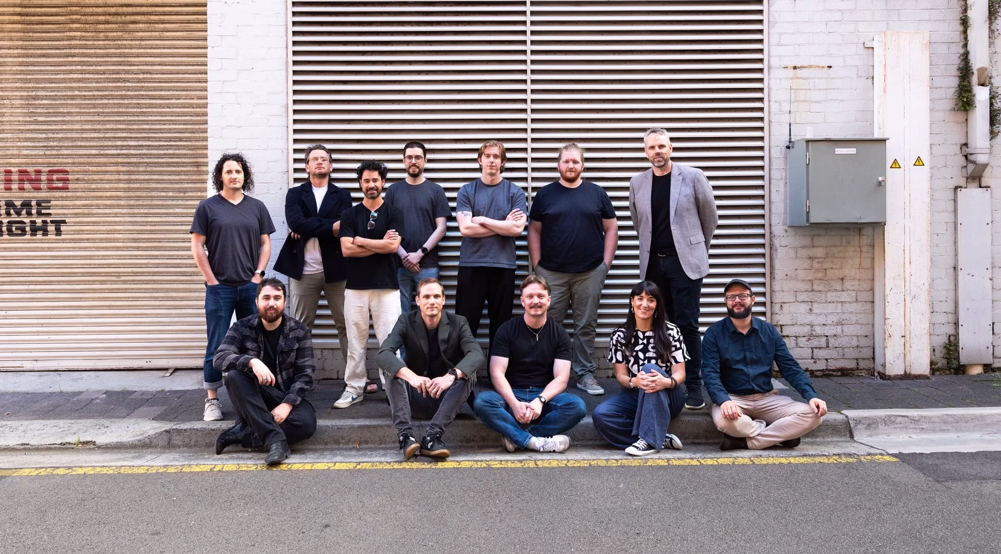 A group of 14 people standing in an urban environment.